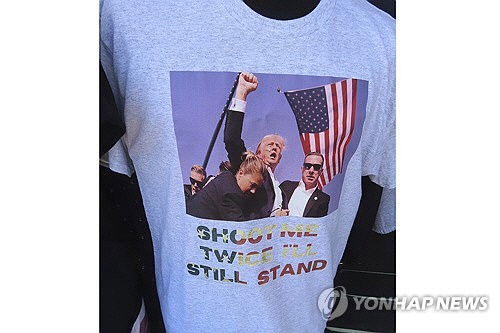 15일(현지시간) 뉴저지주 와일드우드에서 도널드 트럼프 전 미국 대통령의 지난 13일 총격 당시 모습을 인쇄한 티셔츠가 진열돼 있다.   [와일드우드[美뉴저지주] AP=연합뉴스]